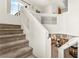 Open staircase landing with carpeted steps leading down to the living area with a fireplace at 9522 Arrowhead Falls Ct, Las Vegas, NV 89148
