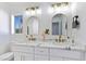 Bathroom featuring double sinks with marble countertop, gold hardware, and modern lighting at 9541 Summersweet Ct, Las Vegas, NV 89123