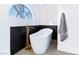 Sleek soaking tub beside a modern gold faucet and accent tile under arched window in contemporary bathroom design at 9541 Summersweet Ct, Las Vegas, NV 89123