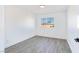 Bright bedroom with white walls, wood-look floors, and a window offering neighborhood views at 9541 Summersweet Ct, Las Vegas, NV 89123