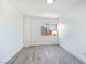 Bright bedroom with white walls, wood-look floors, and a window offering a view of the neighborhood at 9541 Summersweet Ct, Las Vegas, NV 89123