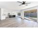 Open-concept living room with wood floors, modern lighting, and sliding glass doors to the backyard at 9541 Summersweet Ct, Las Vegas, NV 89123