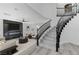 Bright living room showcasing a marble fireplace, sleek ceiling fan, and a stylish staircase with black railing at 9541 Summersweet Ct, Las Vegas, NV 89123
