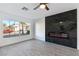 Living room featuring a modern fireplace and a large window with a view of the neighborhood at 9541 Summersweet Ct, Las Vegas, NV 89123