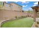 A backyard featuring synthetic turf, with a low block wall and an outdoor fire pit at 9557 Belmont Bay Ave, Las Vegas, NV 89148