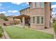 Landscaped backyard featuring synthetic turf and an outdoor fire pit with perimeter seating at 9557 Belmont Bay Ave, Las Vegas, NV 89148