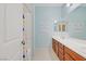 Bright bathroom offering double sinks, white countertops, and a shower-tub with a colorful curtain at 9557 Belmont Bay Ave, Las Vegas, NV 89148