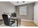 Neutral bedroom featuring a wooden floor, a window with blinds and a desk at 9557 Belmont Bay Ave, Las Vegas, NV 89148