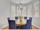 Bright dining room features a modern light fixture and a round wooden table with seating for six at 9557 Belmont Bay Ave, Las Vegas, NV 89148