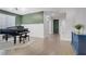 Spacious living room with a grand piano, light wood flooring, and staircase at 9557 Belmont Bay Ave, Las Vegas, NV 89148