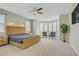 Bright main bedroom featuring a ceiling fan, carpet, and a seating area by a large window at 9557 Belmont Bay Ave, Las Vegas, NV 89148