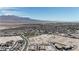 A high aerial view displays a new community nestled near a mountain range, showcasing its expansive layout and development at 9605 Oliver Hills Ave, Las Vegas, NV 89143
