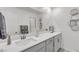 Modern bathroom boasts a large mirror, double vanity, and contemporary fixtures at 9605 Oliver Hills Ave, Las Vegas, NV 89143