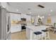 Modern kitchen features stainless appliances, white cabinets, island seating, and tile floors at 9605 Oliver Hills Ave, Las Vegas, NV 89143
