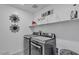 Laundry room with a front load washer and dryer and built in shelves at 9605 Oliver Hills Ave, Las Vegas, NV 89143