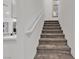 Carpeted stairway with white handrail, complemented by a glimpse of the kitchen at 9605 Oliver Hills Ave, Las Vegas, NV 89143