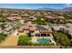 Aerial view of the property, showcasing its large pool, patio area, solar panels, and lush landscaping at 9749 Glistening Brook Ct, Las Vegas, NV 89149