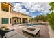 Luxurious backyard features a swimming pool, spa, patio area, and outdoor fireplace, ideal for relaxation at 9749 Glistening Brook Ct, Las Vegas, NV 89149