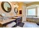 Luxurious bathroom with granite countertops, double sinks, and a soaking tub at 9749 Glistening Brook Ct, Las Vegas, NV 89149