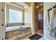 Elegant bathroom featuring a tub with granite surround and a tiled shower at 9749 Glistening Brook Ct, Las Vegas, NV 89149