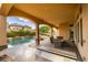 Inviting outdoor area featuring a covered patio, built-in grill, and a refreshing swimming pool with waterfall features at 9749 Glistening Brook Ct, Las Vegas, NV 89149