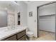 Modern bathroom with tile floors, a marble-topped sink, decorative lighting, and a closet at 10078 Delicate Dew St, Las Vegas, NV 89183