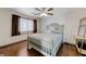 Bedroom featuring a ceiling fan, hardwood flooring, and neutral colored paint at 10078 Delicate Dew St, Las Vegas, NV 89183