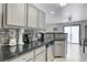 Bright kitchen with black countertops, stainless appliances, and a view into the dining area at 10078 Delicate Dew St, Las Vegas, NV 89183