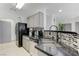 Bright kitchen area with granite countertops, black appliances, and a stylish mosaic backsplash at 10078 Delicate Dew St, Las Vegas, NV 89183