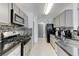 Galley kitchen featuring sleek appliances, gray cabinets, and mosaic backsplash for a modern look at 10078 Delicate Dew St, Las Vegas, NV 89183