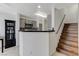 Cozy kitchen featuring gray cabinets, black countertops, a stylish backsplash, and staircase access at 10078 Delicate Dew St, Las Vegas, NV 89183