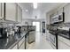 Galley kitchen with modern appliances, light gray cabinetry, and mosaic backsplash, open to the dining area at 10078 Delicate Dew St, Las Vegas, NV 89183