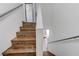 Wooden staircase with handrails and views of the dining room and an additional living space at 10078 Delicate Dew St, Las Vegas, NV 89183