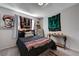 Bedroom featuring a dark wood bed frame, eclectic art on the walls, and a patterned blanket on the bed at 10342 Adrianna Ave, Las Vegas, NV 89129