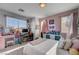 Light-filled bedroom with a desk, carpet flooring, and a pink accent wall at 10342 Adrianna Ave, Las Vegas, NV 89129