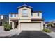 Two-story home featuring a two-car garage, desert landscaping and tile roofing under a clear blue sky at 10342 Adrianna Ave, Las Vegas, NV 89129