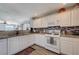 The kitchen has granite counters, white cabinets, stainless appliances and a mosaic backsplash at 10342 Adrianna Ave, Las Vegas, NV 89129