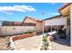 Charming backyard featuring gravel landscaping, a covered patio and brick retaining wall, perfect for outdoor enjoyment at 1057 Neil Armstrong Cir, Las Vegas, NV 89145