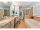 A luxurious bathroom with a double vanity, a soaking tub, and a glass-enclosed shower at 1057 Neil Armstrong Cir, Las Vegas, NV 89145