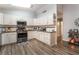 Open kitchen showcasing white cabinets, stainless steel appliances and hardwood floors at 1057 Neil Armstrong Cir, Las Vegas, NV 89145