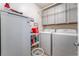 Well-organized laundry room featuring a washer, dryer, storage cabinets, and shelving for supplies at 1057 Neil Armstrong Cir, Las Vegas, NV 89145