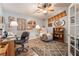 Inviting office space with a ceiling fan, desk, chair, comfortable recliner, and decorative shelving at 1057 Neil Armstrong Cir, Las Vegas, NV 89145