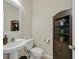 Cozy powder room with a pedestal sink, decorative mirror, and a storage cabinet for added convenience at 11695 Rossovino St, Las Vegas, NV 89183