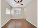 Well-lit bedroom showcasing hardwood floors, a ceiling fan, and a window providing natural light and a view of the exterior at 11695 Rossovino St, Las Vegas, NV 89183