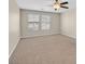 Spacious bedroom featuring neutral carpet, a ceiling fan, and large windows that provide natural light at 11695 Rossovino St, Las Vegas, NV 89183
