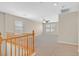 Bright loft space featuring neutral carpeting, a ceiling fan, and plenty of natural light from the windows at 11695 Rossovino St, Las Vegas, NV 89183