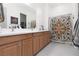 Bathroom with double sink vanity, tiled floors, and decorative shower curtain at 12844 New Providence St, Las Vegas, NV 89141