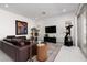 Spacious living room with a leather sofa, modern decor, bright lighting, and sliding door access at 12844 New Providence St, Las Vegas, NV 89141