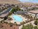 Aerial view of community pool with lounge chairs, tables, pergola, and mountain views at 12844 New Providence St, Las Vegas, NV 89141