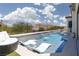 Relaxing pool with two lounge chairs and waterfall feature, perfect for enjoying sunny days at 12844 New Providence St, Las Vegas, NV 89141